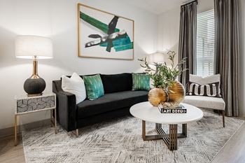 a living room with a black couch and a white coffee table